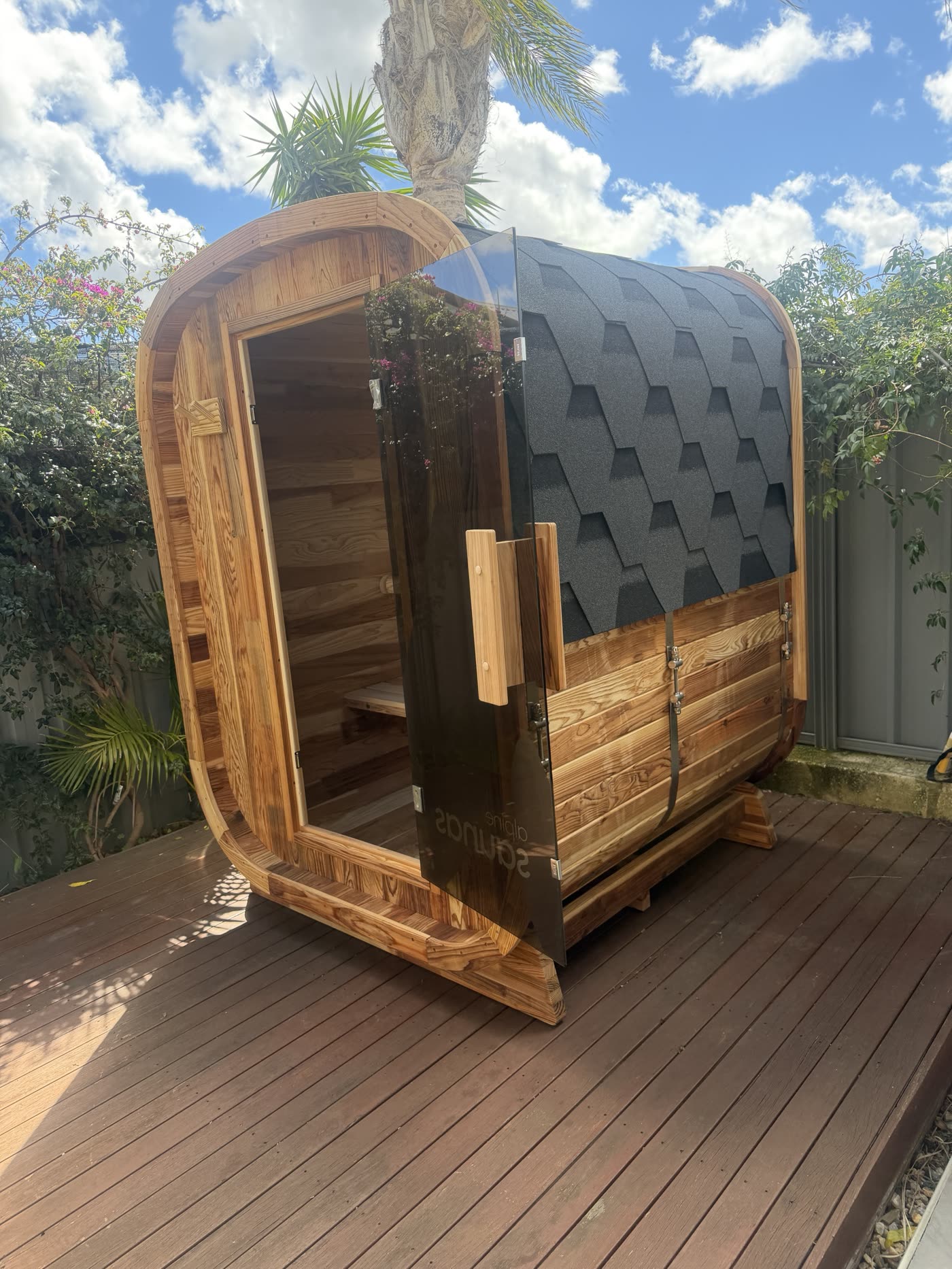 Outdoor barrel sauna on a timber deck, ready for power