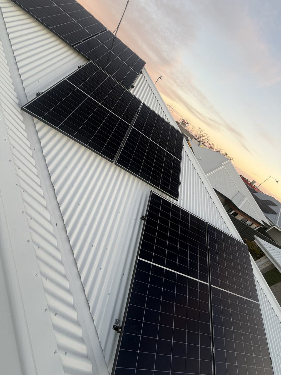 Solar panels on a white Colorbond roof at dusk