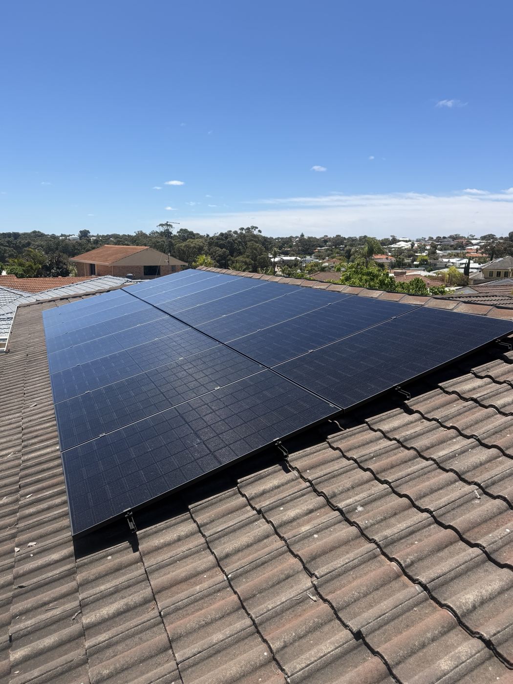 Solar panels on a tiled roof under a clear blue sky
