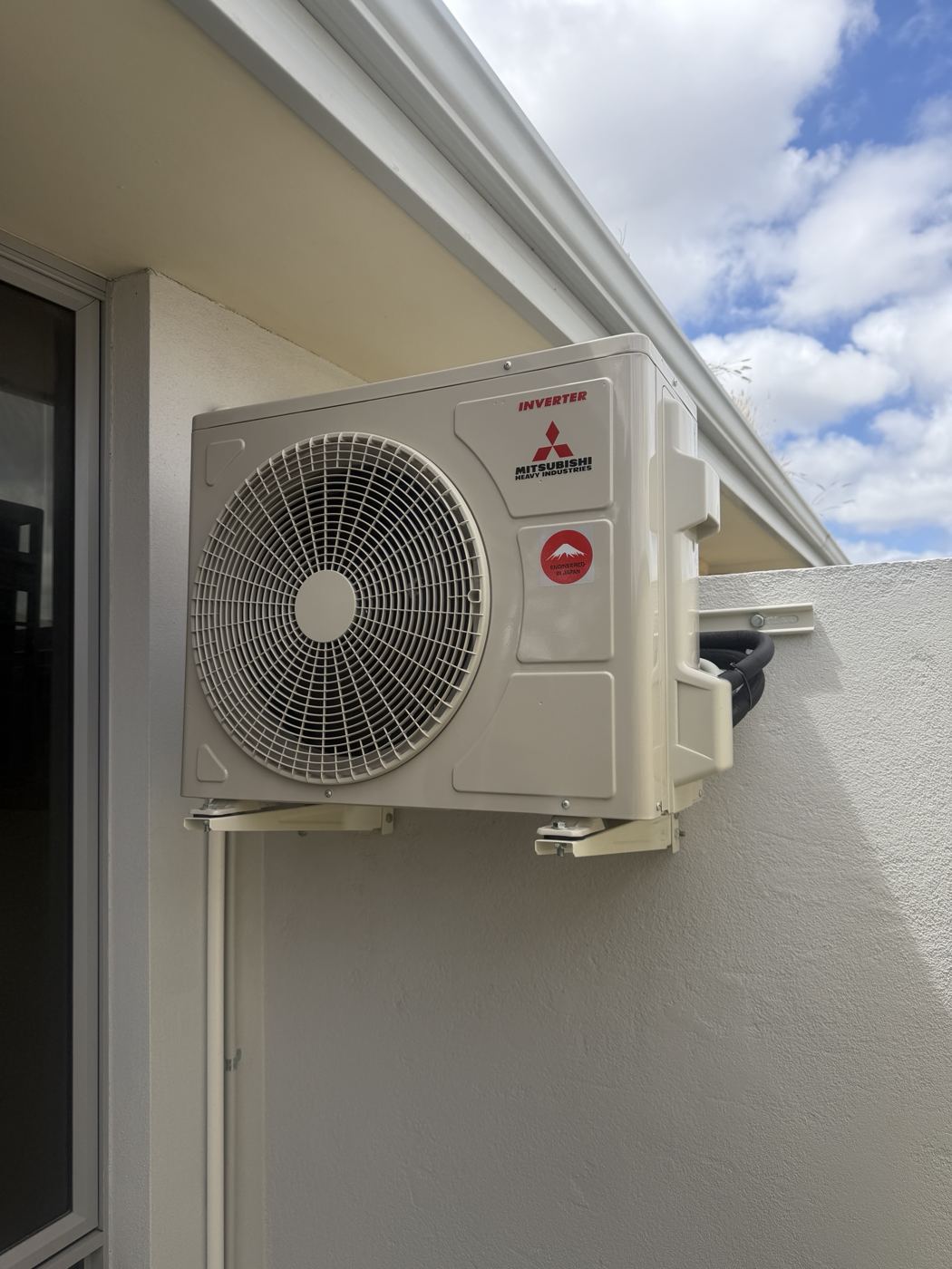Outdoor air conditioning unit mounted on a wall bracket